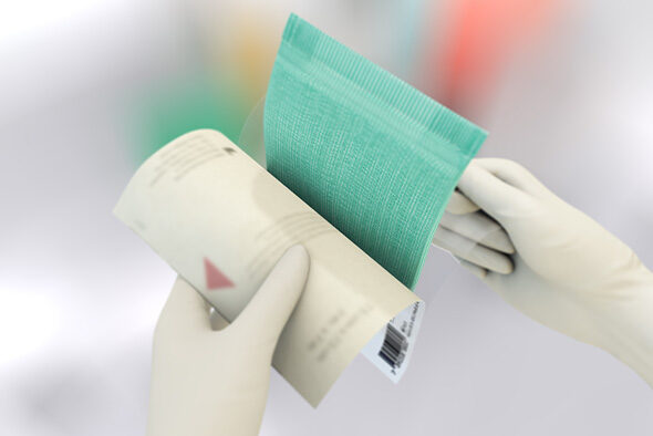 Person åpner innerpakken til en Sorbact Absorption-bandasje.